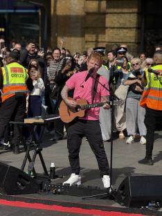 Ed Sheeran performing at King's Cross station in London.