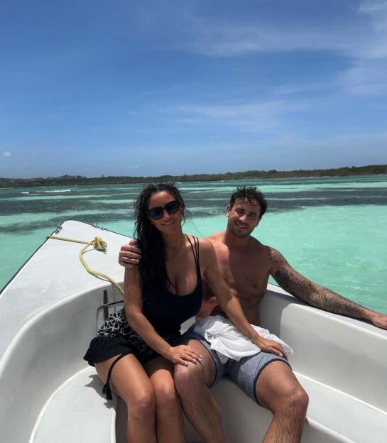 Couple on a boat in turquoise water.