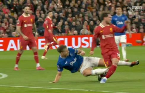 Soccer players tackling on the field.