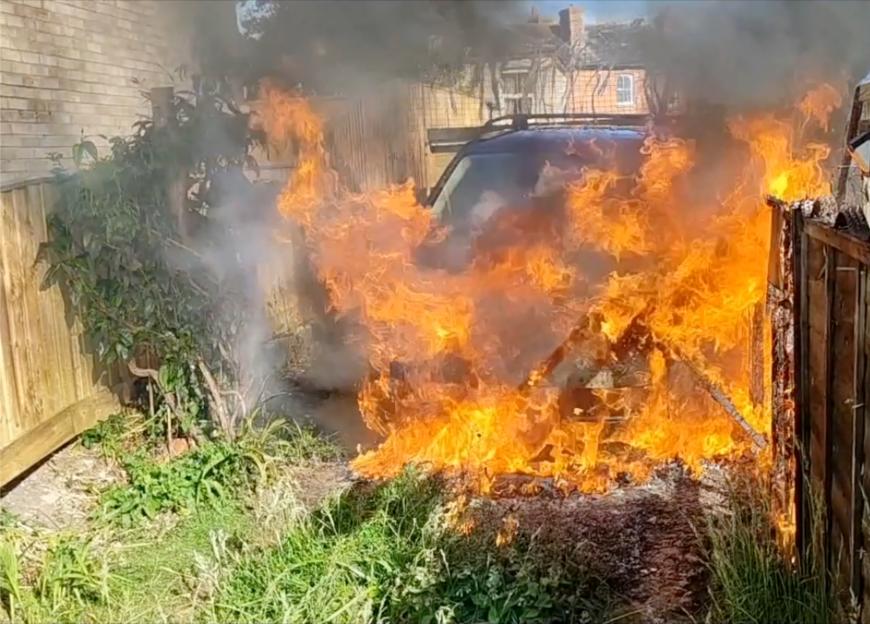 A Land Rover engulfed in flames.