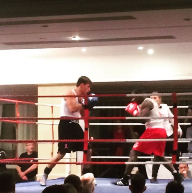 Fincham boxing in the ring, wearing a white vest and black shorts.