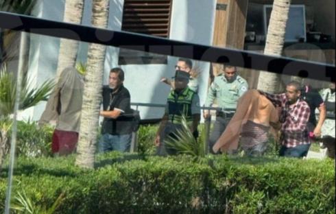 People being detained by security personnel.