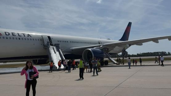 Delta plane catches fire on runway in Orlando with flames seen engulfing aircraft as passengers rush to escape blaze