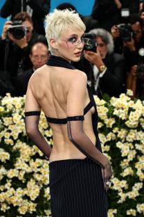 Emma Chamberlain at the Met Gala in a backless pinstripe suit.
