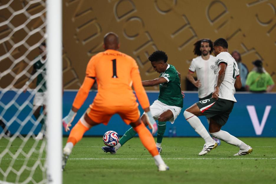 A soccer player kicks the ball toward the goal during a match.