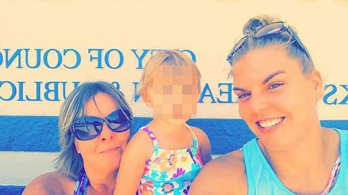 Photo of two women and a child, the child's face is blurred.