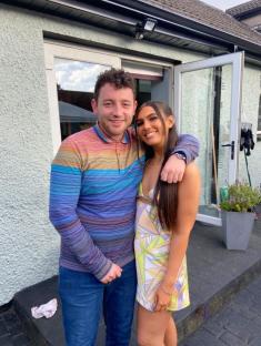 Photo of a man and woman posing together outdoors.