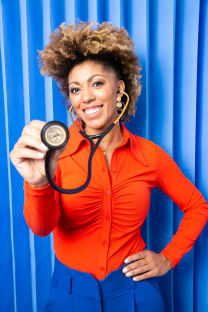 Woman in orange shirt holding stethoscope.