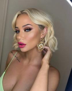 Close-up of a woman with blonde hair and gold earrings.