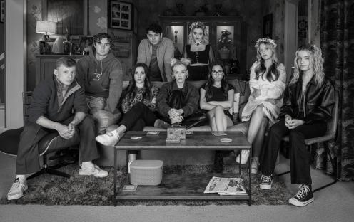 Black and white photo of a group of young adults sitting on a couch.
