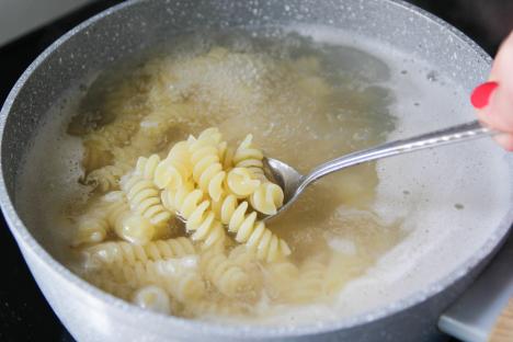 Fusilli pasta cooking in a pot.