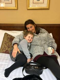 A grandmother and her granddaughter sitting on a bed.