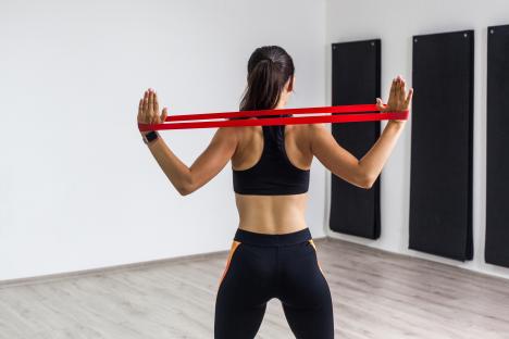 Woman doing back exercises with resistance band.