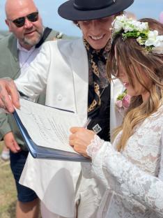 Bride and groom signing their marriage certificate at Glastonbury Festival.