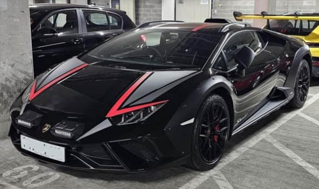 Black Lamborghini HuracÃ¡n with red stripes.