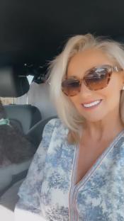 Screenshot of a woman in a car with a dog.