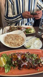 Grilled meat skewers with rice and salad.