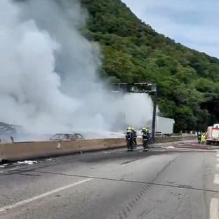 Firefighters battling a large fire on a highway caused by an overturned tanker truck.