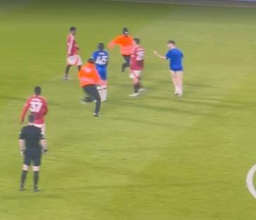 Soccer players and a referee on a field.