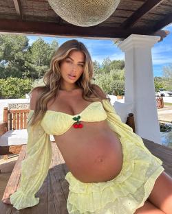 Pregnant woman in a yellow eyelet outfit.