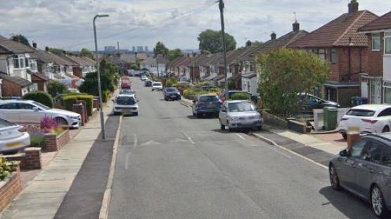 Residential street with parked cars.