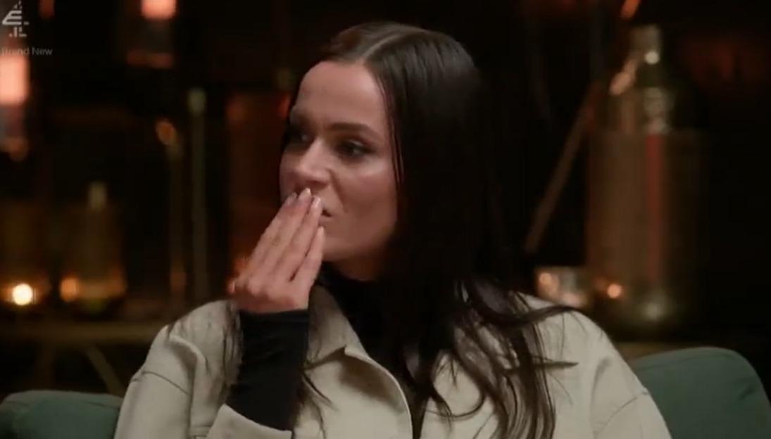 Woman covering her mouth with her hand, appearing upset.