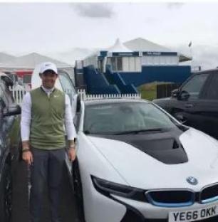 Rory McIlroy standing next to a BMW i8.