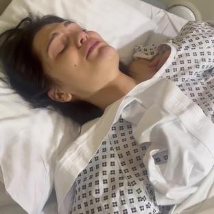 Jessie J crying in a hospital bed after breast cancer surgery.