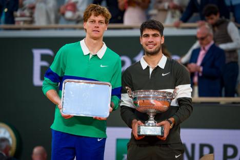 Carlos Alcaraz of Spain and Jannik Sinner of Italy holding trophies after a tennis match.