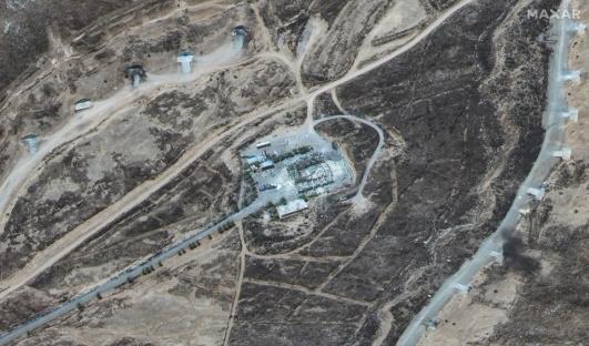 Aerial view of a damaged building and surrounding structures.