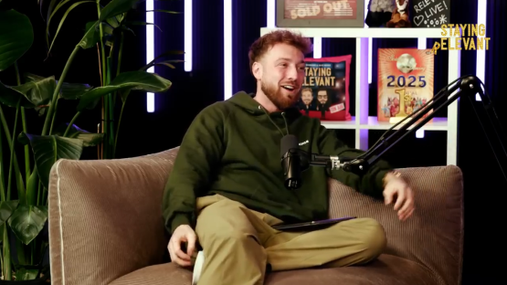 Man sitting on a couch during a podcast recording.