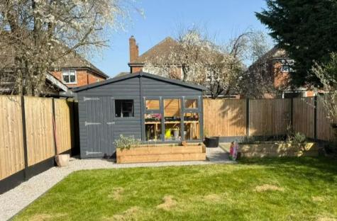 Backyard with shed and raised garden beds.