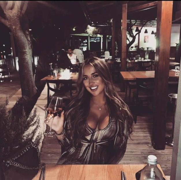 Farran Tomlin at a restaurant, holding a glass of wine.