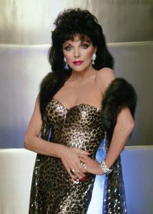 Joan Collins in a leopard print gown and fur stole.