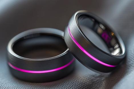 Two dark gray rings with a pink stripe.