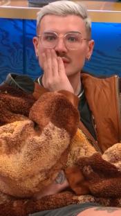 Man in glasses covering his mouth with his hand.