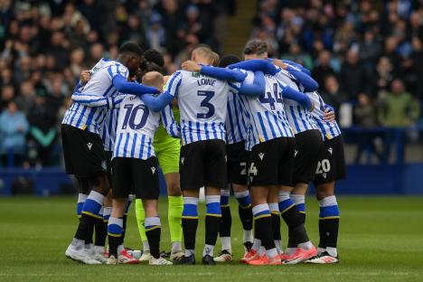 Sheffield Wednesday soccer players huddled together on the field.