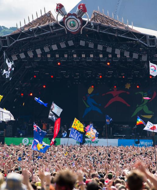 Large crowd at a music festival in front of a stage.