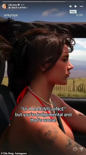 Video of a woman driving and reacting to a comment.