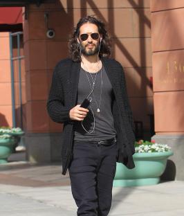 Russell Brand walking down the street.