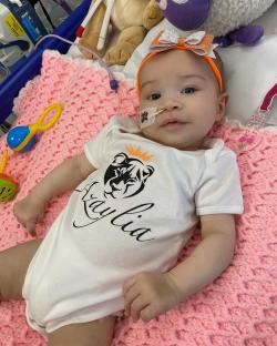 Baby girl wearing a onesie that says "Azaylia".