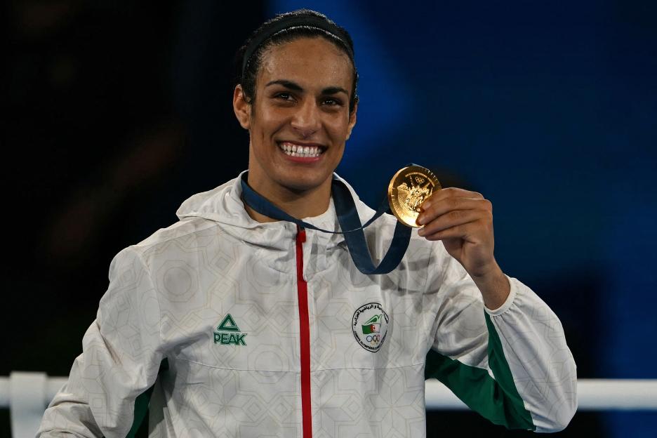 Algerian boxer Imane Khelif holding her gold medal at the 2024 Paris Olympics.