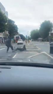 A street fight where a person is kicked while lying on the ground.