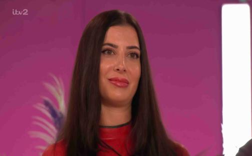 A woman with long dark hair wearing a red top.