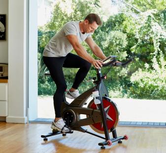 Man exercising on a stationary bike at home.