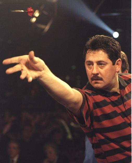 Dennis Priestly throwing a dart.