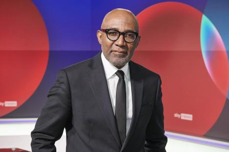 Trevor Phillips in a suit and glasses.
