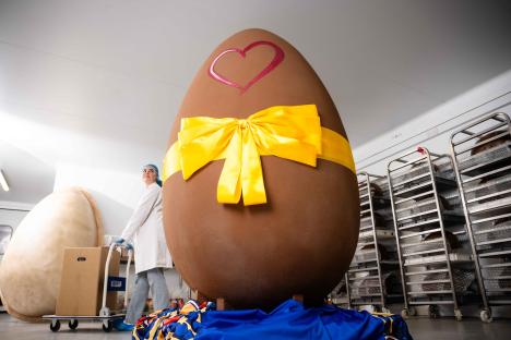 A giant chocolate Easter egg with a yellow bow and a heart painted on it.