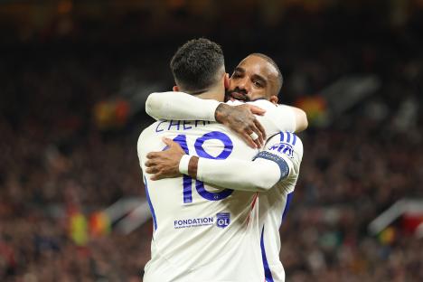 Rayan Cherki and Alexandre Lacazette celebrating a goal.