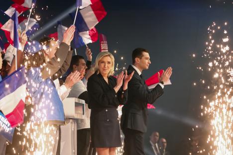 a man and a woman are applauding while holding flags
